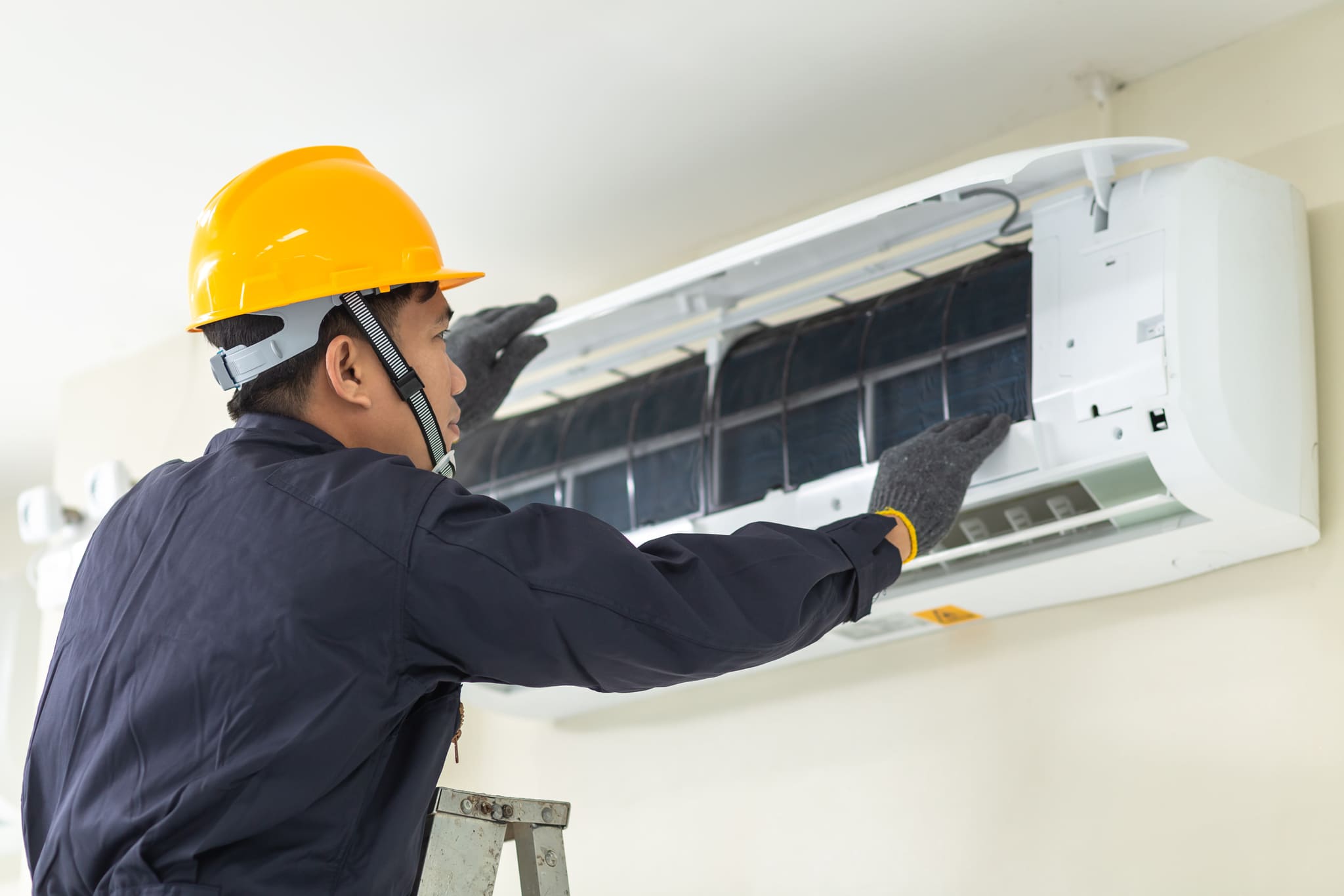 male technician repairing air conditioner